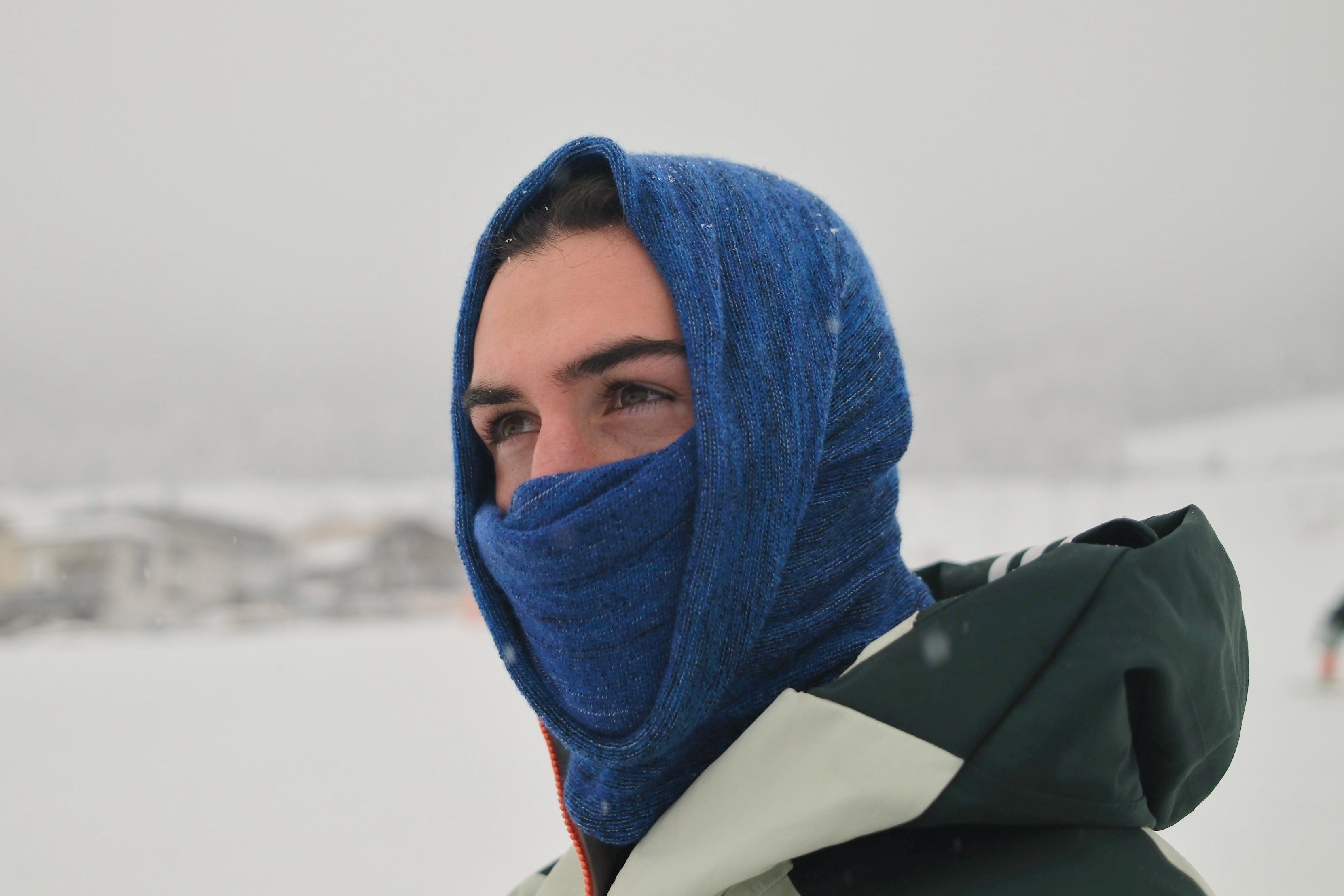 Person wearing a blue hooded jacket in a snowy landscape
