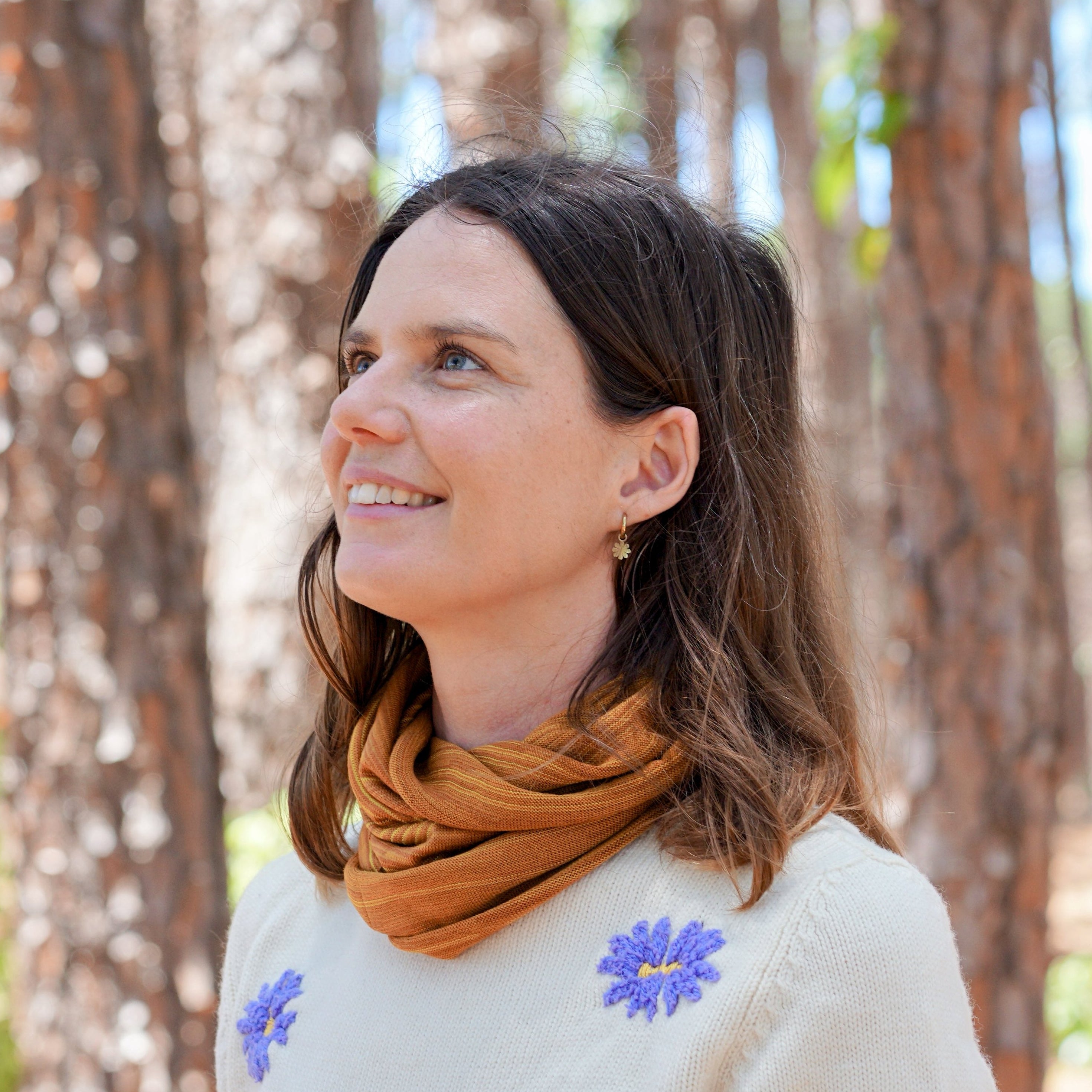 Woman standing in a forest with trees in the background